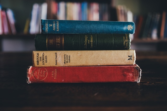 classic study desk with globe, green desk lamp and stacked books