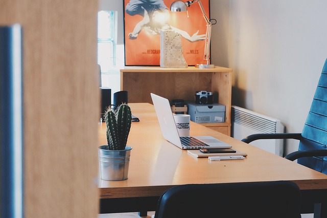study desk vignette with globe, brass accessories, green lamp and stacked books